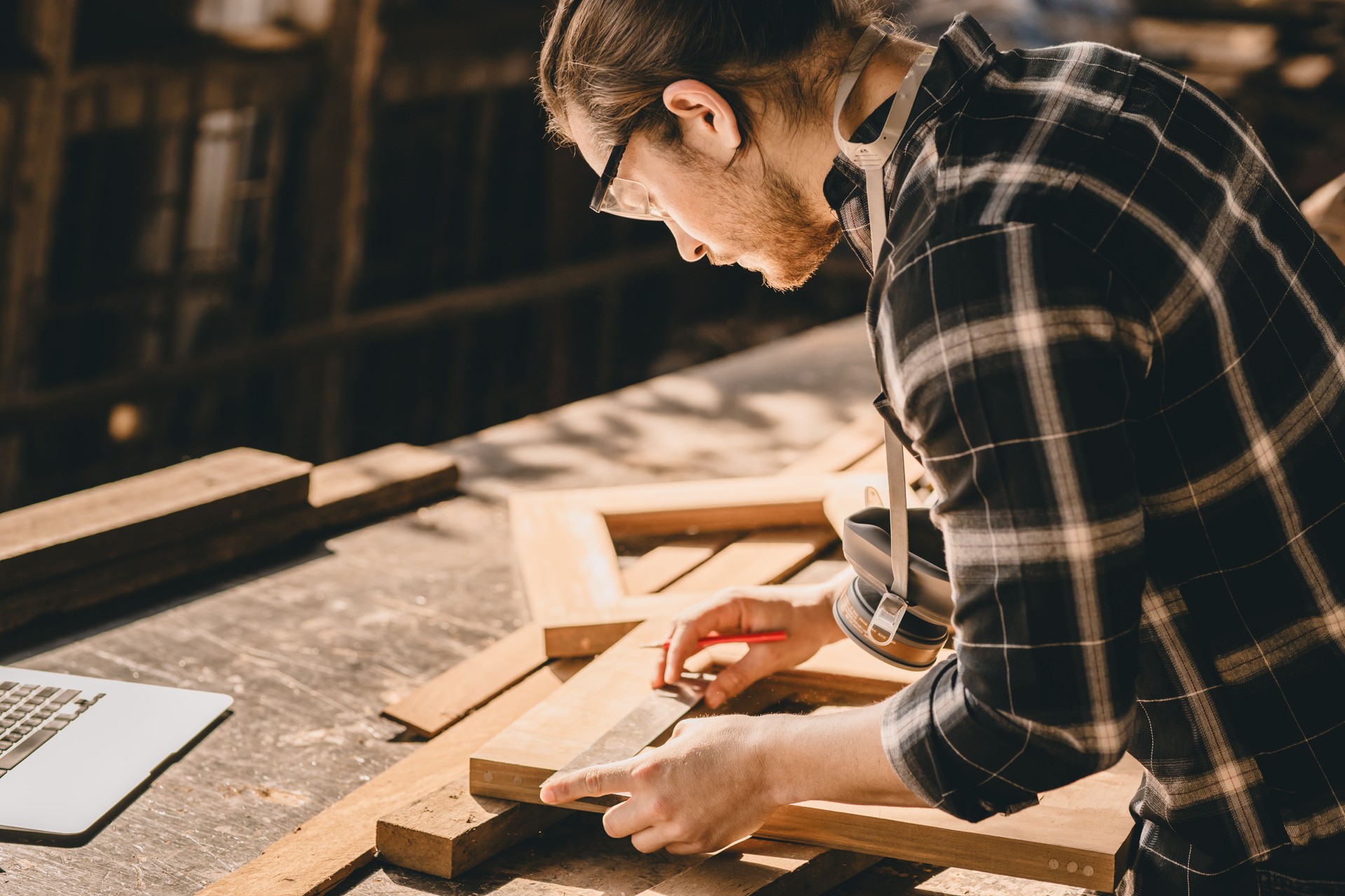 Carpenter Joiner man making wooden furniture in wood workshop professional high skill real authentic handcrafted working people.